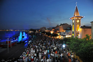 Foule sur la promenade nocturne, église illuminée