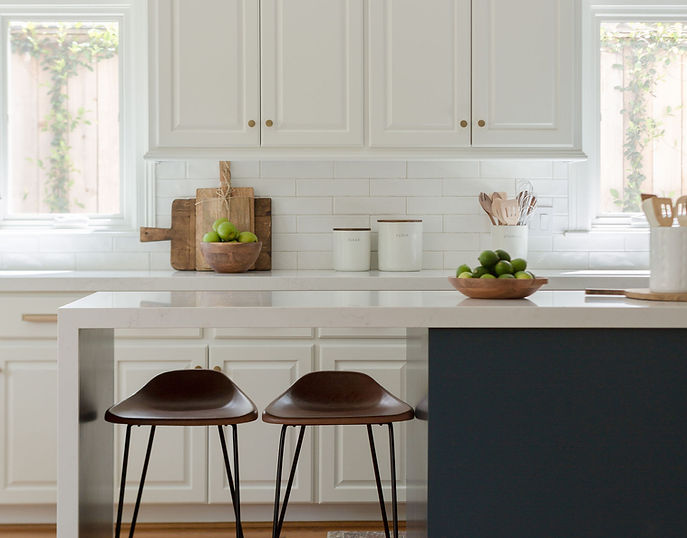 ​We fondly call this project our "Whole House Half House"! This project’s nickname comes from the fact that we transformed the whole house in new paint from stem to stern, with finished construction only on the lower half or main first floor. Our minor renovation delivered a major transformation without having to take the home down to the studs!

Scope of work:
We updated the kitchen, powder room, bar area, fireplace surround and added new decor in the​ living room and kitchen, with new paint including walls, trim, and ceiling throughout all three floors.​ By repainting the entire home in a soft off-white, we provided a fresh backdrop that unified the interiors.​ In the kitchen, we replaced dark countertops and backsplashes with textured white subway tiles and​ quartz surfaces to achieve a lighter, more open feel. The existing island was extended into a waterfall design that accommodates additional counter seating, while brass hardware adds warmth and a touch of modernity. We also reimagined the underutilized desk area, converting it into concealed storage with custom cabinetry that seamlessly blends with the kitchen's modern traditional aesthetic.

Throughout the home, thoughtful updates like the new fireplace surround and new light fixtures​ revitalized the space, making it both functional and inviting. 

For more details check out our blog post here:
https://www.nancylaneinteriors.com/post/whole-house-half-house-project-before-after-reveal
