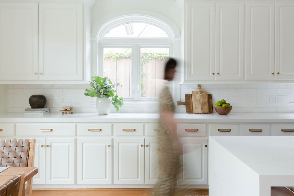 Modern transitional whole house renovation rejuvenation by Houston interior design firm Nancy Lane Interiors including updated all white kitchen featuring new elongated waterfall island painted in blue with space for open seating.