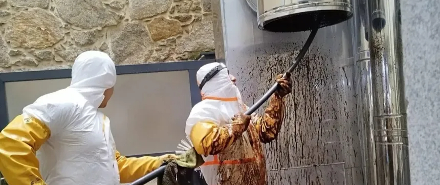 Técnicos limpiando una chimenea con espuma y cepillo