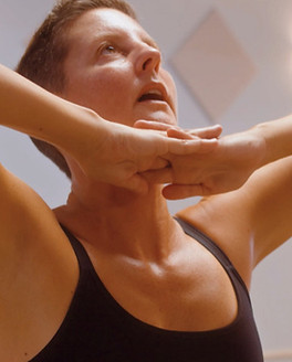 Yoga sol membership group performing yoga stretches in a studio group class.