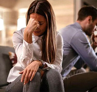 Traurige Frau mit nachdenklichen Mann im Hintergrund