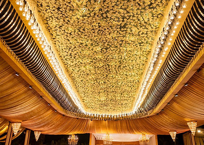 Banquet hall ceiling covered with hanging flowers and warm lights