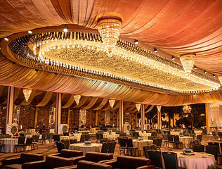 Banquet hall with draped ceiling and chandeliers by Kauvery Events