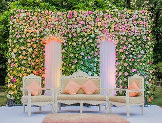Pastel floral wall stage with sofa seating by Kauvery Events