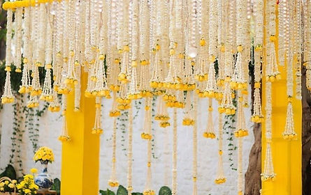 White and yellow flower garland backdrop for a haldi function