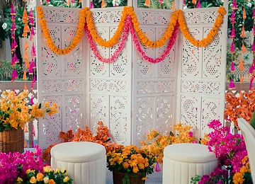 White jaali backdrop with marigold garlands for a home function
