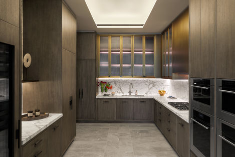 a kitchen with wooden cabinets and marble counter tops