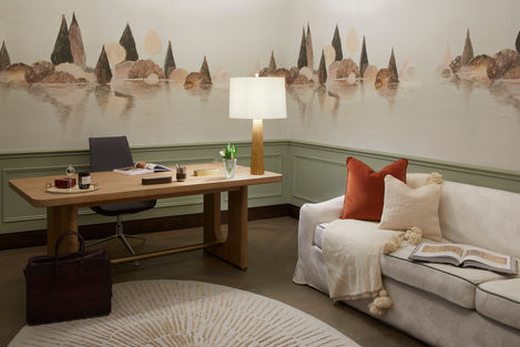 a living room with a desk chair and a lamp