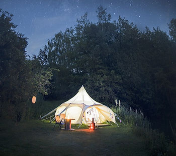 Stargazer glamping tent at night lit up with stars in the sky