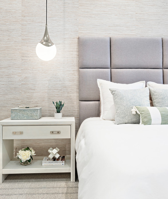 Master bedroom with grey cool tones and teal and green accents. Custom headboard. Hanging pendants.