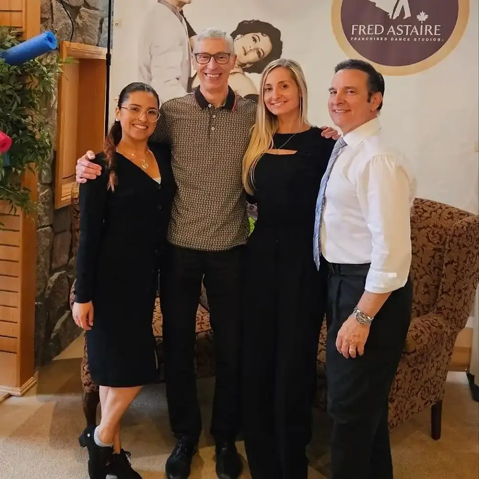Group of adults smiling together at a dance studio, representing adult beginner dance classes with friendly instructors and a welcoming learning environment.