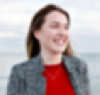 happy-smiling-long-haired-woman-with-big-blue-eyes-red-shirt-grey-coat-walks-near-sea_edit