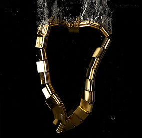 Fluid Necklace in 18k gold-plated bronze submerged in water, highlighting articulated square elements and fluid movement