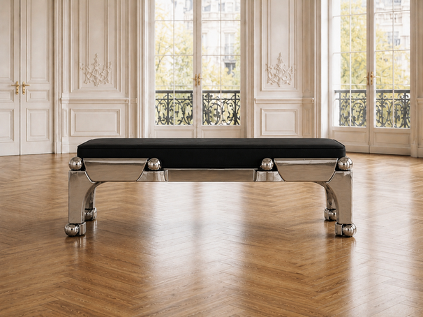 Frontal view of the Orbital bench with polished steel legs, spherical details, and black upholstered seat in a bright classical room.