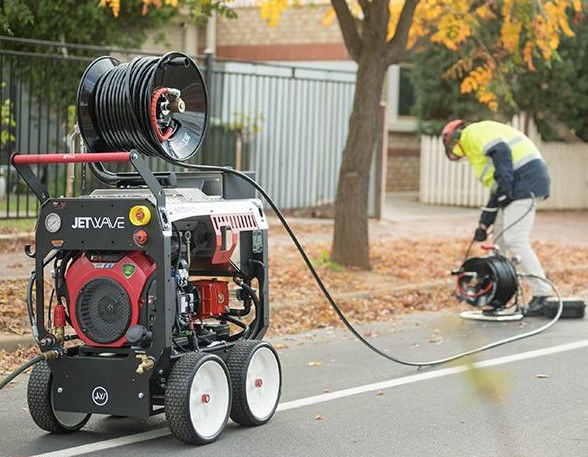 Plumber using jetting equipment for hot water service repairs melbourne