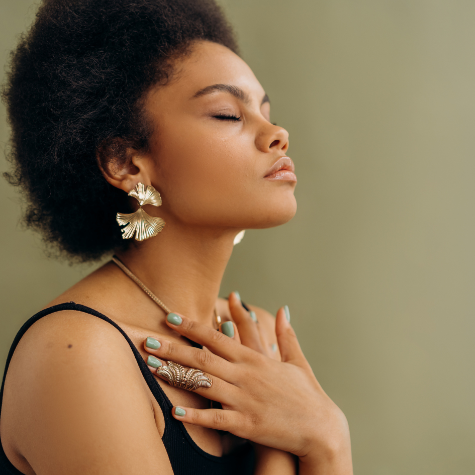 black woman with hands on chest, eyes closed, meditating