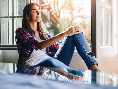 a woman breathing fresh air in her home