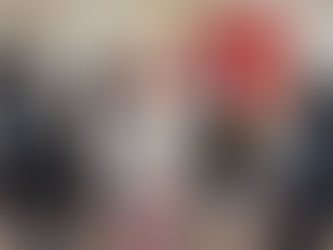 Teilnehmende stehen um einen Stehtisch und schauen auf einen Bildschirm