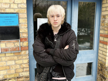 Portraitfoto Guilio vor dem Eingang von Schule und Beruf Berlin e.V.