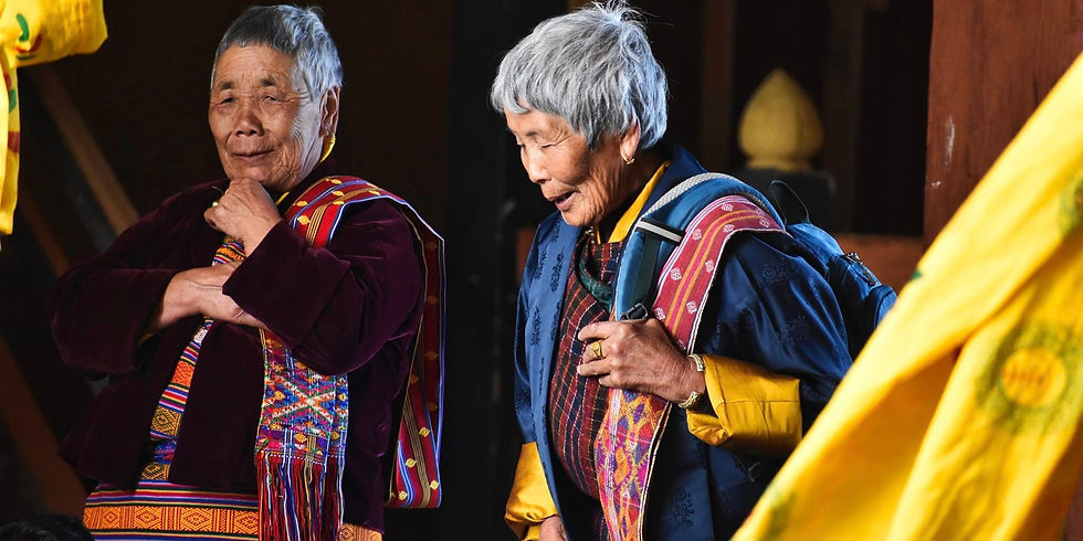 Frauen tragen mit Stolz ihre farbenfrohe, traditionelle Tracht mit kunstvoll gewebten Mustern.