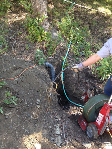 Technician performing professional drain cleaning with hydro-jetting equipment