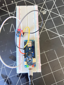 Close-up of an Arduino MKR WiFi 1010 connected to an MPU-6050 accelerometer and gyroscope sensor on a white breadboard using jumper wires. The setup is powered through USB-C, with indicator LEDs illuminated on both the microcontroller and sensor module.