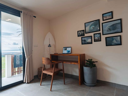 Private guest bungalow interior showcasing a modern wooden laptop work desk, closet, and safety storage.