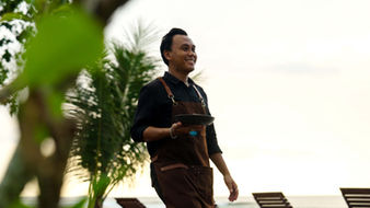 The Ujung Bocur open-plan restaurant at sunset with warm ambient lighting and views of the Sumatra coastline.