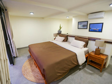 Comfortable twin share bedroom featuring air conditioning, mosquito nets, and clean linen at a premium surf camp.