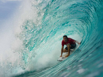 Expert surfer dropping down the face of a heavy, hollow tube at Way Jambu reef break in South Sumatra.