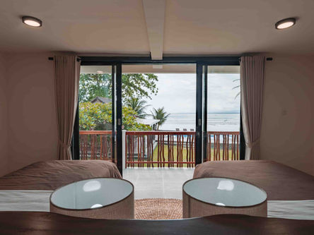 Comfortable twin share bedroom featuring air conditioning, mosquito nets, and clean linen at a premium surf camp.