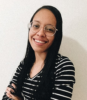 uma foto da crítica maryana sorrindo usando oculos