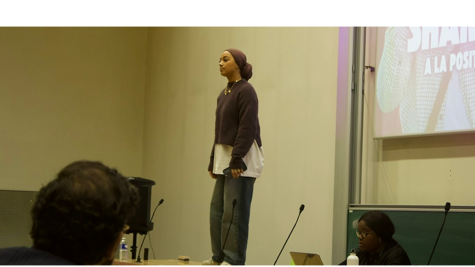 Inès prenant la parole sur scène, illustrant l’affirmation de soi, l’authenticité et le leadership féminin hors des cases