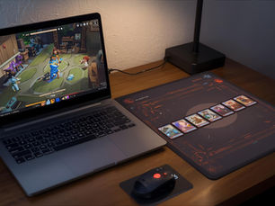 Digital deckbuilding game displayed next to physical trading cards showing the connection between digital and tabletop card games.