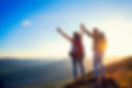 happy couple man and woman tourist at top of mountain at sunset outdoors during a hike in