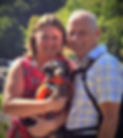 the breeders behind High Desert companions; Husband and wife, holding a pet dog.