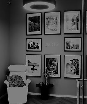 Moderner Eingangsbereich der NOIR Sporttherapie mit einladendem Empfang und stilvoller Gestaltung.