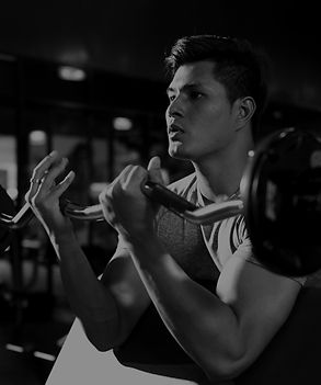 Bereich für Krafttraining im NOIR Gym mit verschiedenen Geräten wie Langhanteln und Gewichtsmaschinen.