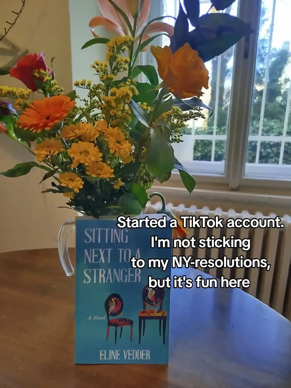 flower and book sitting next to a stranger