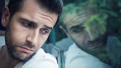 Sad young man looking through the window__.jpg