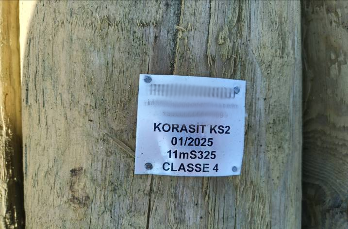 White tag nailed to pole with text: "KORASIT KS2, 01/2025, 11mS325, CLASSE 4".