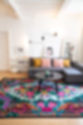 tapis moldave avec un canapé d'angle et des coussins décoratifs des tableaux design une lampe d'angle