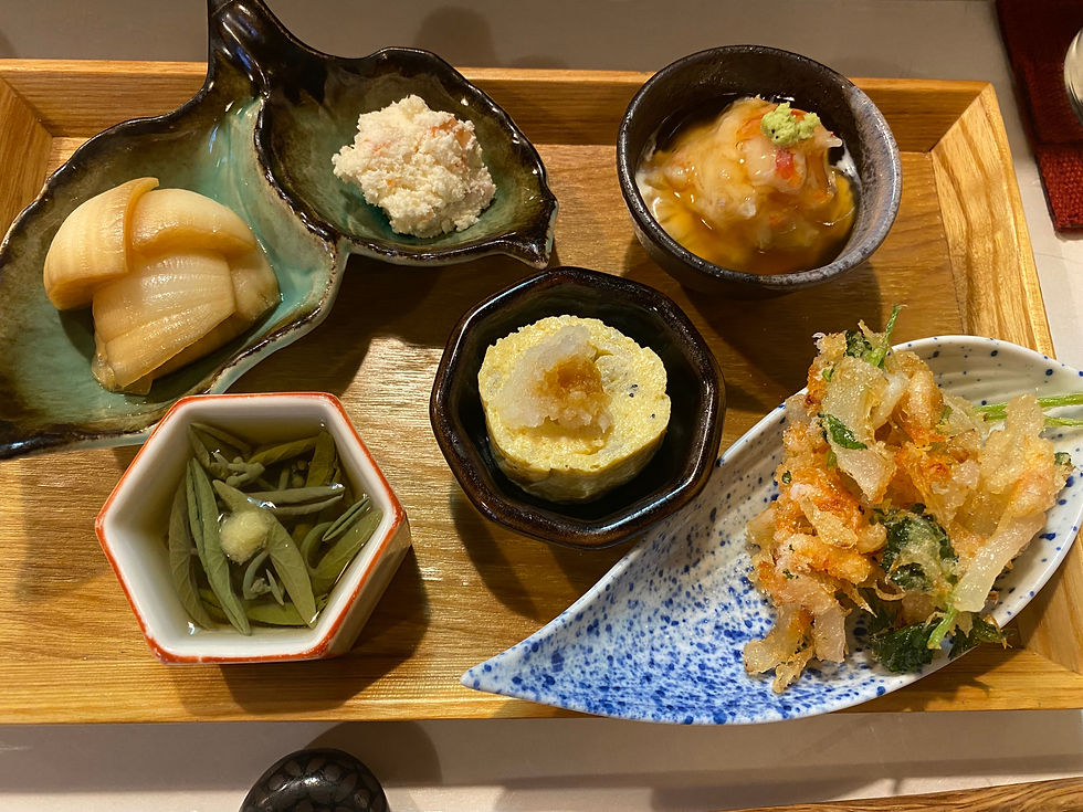 a kaiseki dinner with vegetables, egg, fish, tenpura and potato salad dishes