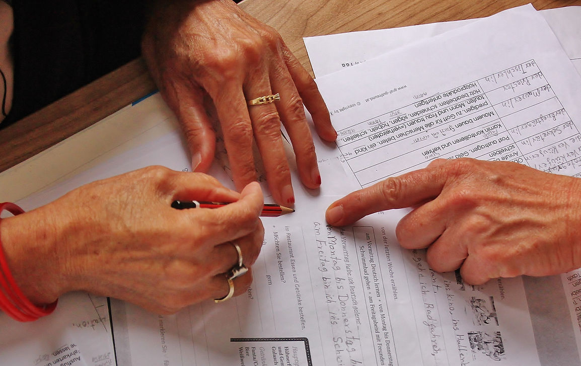 Frauen schreiben auf ein Stück Papier um die Bildungsarbeit des Vereins zu symbolisieren