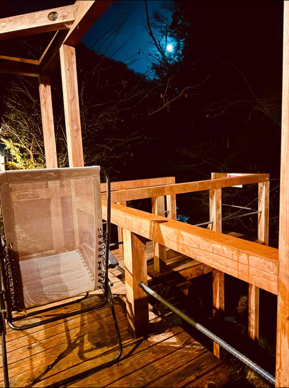 Outdoor sauna relaxation area surrounded by nature at night