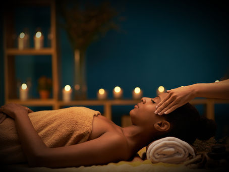 A woman enjoys a soothing facial in a serene setting, surrounded by the warm glow of candles.