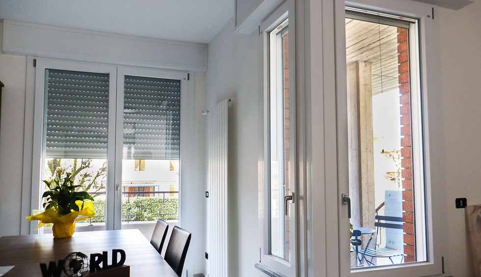 Infissi in PVC bianchi con tapparelle in un interno moderno.