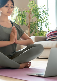 Young healthy mindful indian woman wear sportswear meditate namaste hands watch online cla