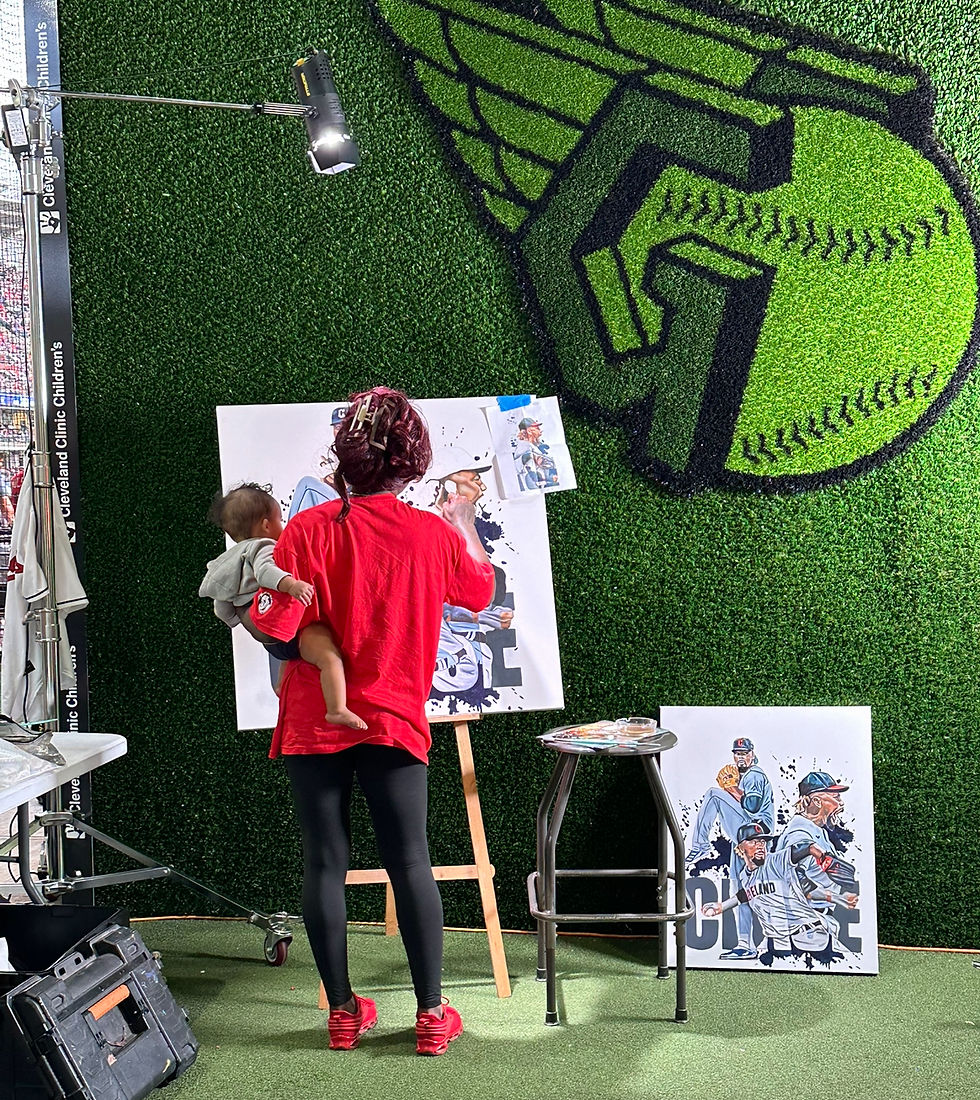 artist Stina Aleah painting live with baby on her hip